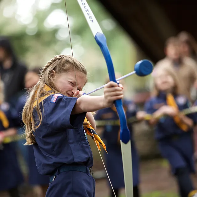 A Cub Scout taking aim at an archery range