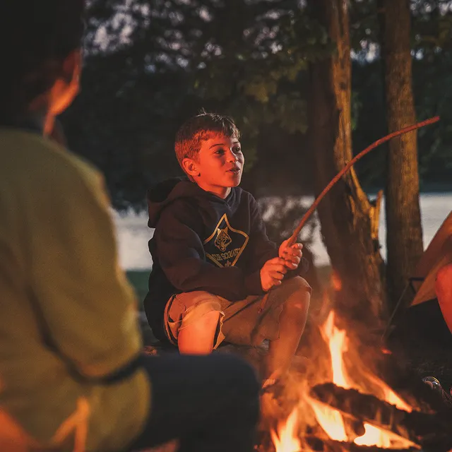 Cub Scouts around a campfire in the evening