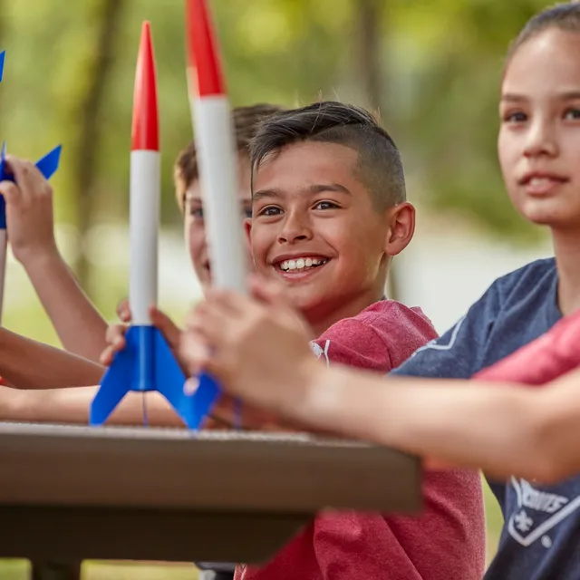 Cub Scouts holding model rockets they built